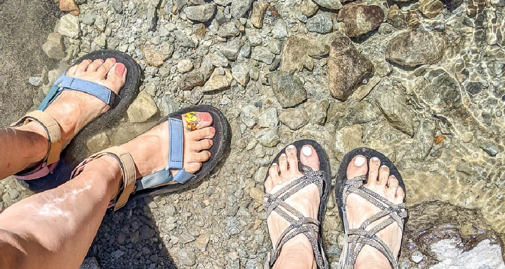 looking down at two pairs of feet in some hiking sandals