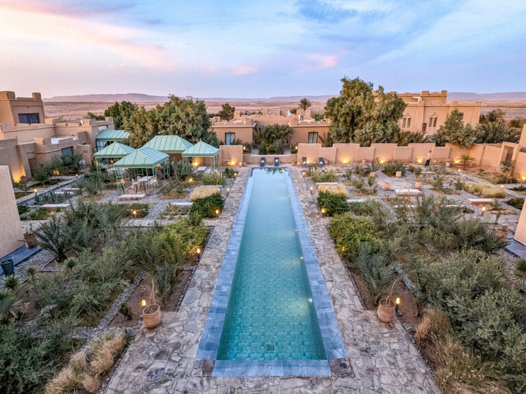 a sandcastle looking hotel with a pool down the middle as seen from above