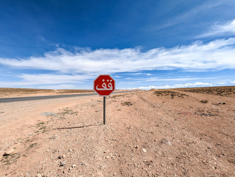 stop sign in the middle of nowhere under a blue sky