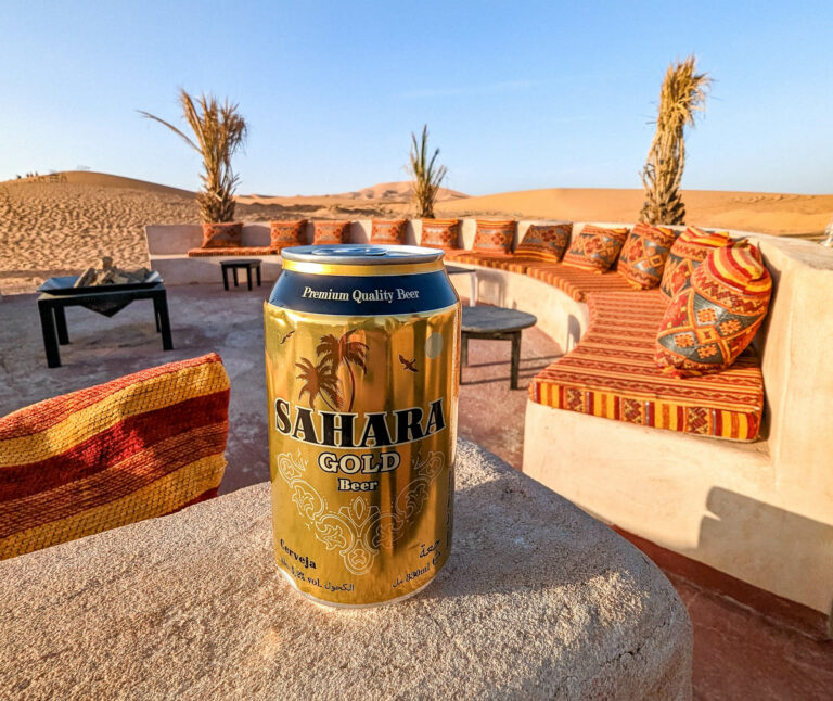 golden can of Sahara Gold beer on a concrete ledge in the desert