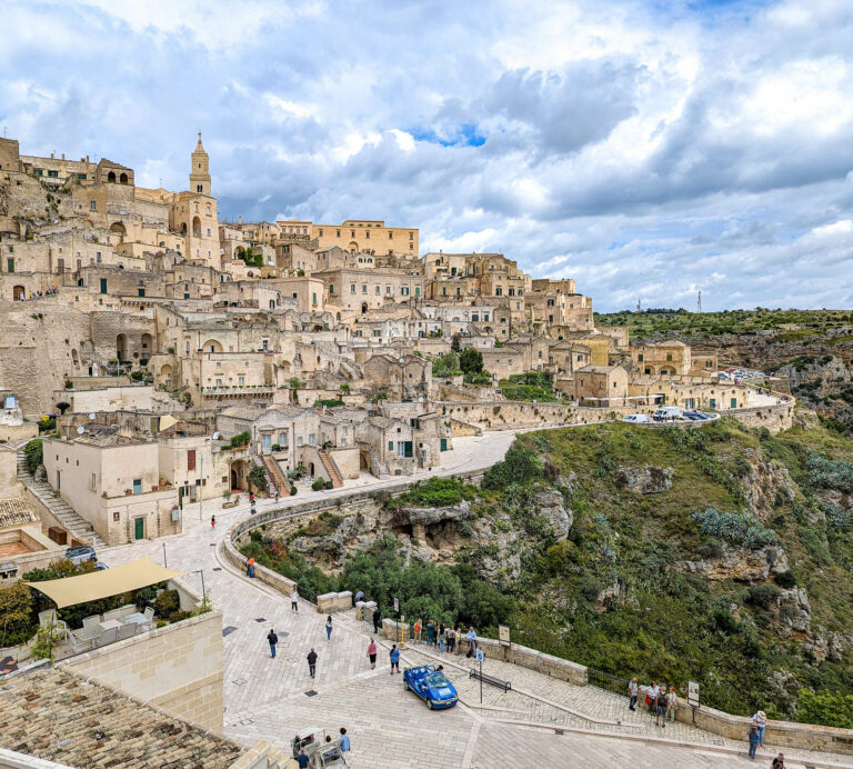 view of the beige stone city on a hill with a church on top