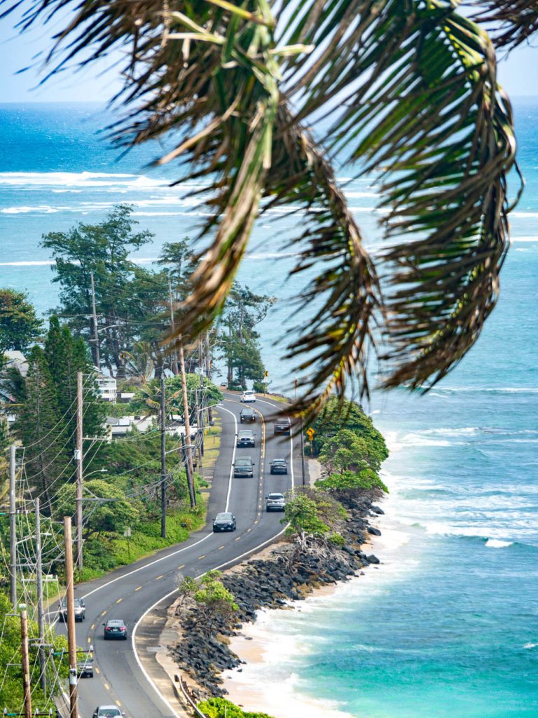 overhead view of cars driving on a road next to the ocean